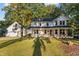 A charming two-story white home features a welcoming front porch and a well-manicured lawn at 347 Cook Rd, Elon, NC 27244