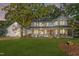 Charming two-story home featuring a covered front porch and attached garage in a lush, green yard at 347 Cook Rd, Elon, NC 27244