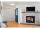 Bright living room with a brick fireplace, stylish blue door, and natural hardwood floors at 3490 Old Buies Creek Rd, Angier, NC 27501