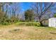 Spacious backyard with mature trees and a storage shed, offering privacy and room for outdoor activities at 369 Albany St, Burlington, NC 27215