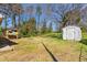 View of the backyard that is mostly lawn, with an outbuilding at 369 Albany St, Burlington, NC 27215