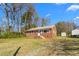 Side view of a brick house featuring a lush lawn and a detached storage shed at 369 Albany St, Burlington, NC 27215