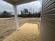 View of the new back porch in a wooded area, featuring wooden slats and a sturdy support column at 381 Old Fashioned Way, Lillington, NC 27546