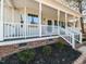 Inviting front porch with white railings, brick accents, and manicured landscaping at 382 Tomahawk Dr, Clayton, NC 27520