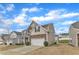 Attractive two-story home with a stone-accented facade, well-kept lawn, and a two-car garage under a partly cloudy sky at 3925 Massey Pointe Ct, Raleigh, NC 27616
