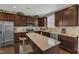 Well-lit kitchen with granite countertops, stainless steel appliances, and a functional center island with barstool seating at 3925 Massey Pointe Ct, Raleigh, NC 27616