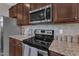 Well-equipped kitchen with stainless steel appliances, granite countertops, and dark wood cabinetry at 3925 Massey Pointe Ct, Raleigh, NC 27616