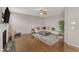 Bright living room featuring a fireplace, stylish seating, and hardwood floors, complemented by a ceiling fan at 3925 Massey Pointe Ct, Raleigh, NC 27616