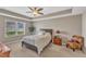 Cozy bedroom with tray ceilings, a ceiling fan, and a large window for ample natural light at 3925 Massey Pointe Ct, Raleigh, NC 27616