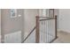 Well-lit staircase with wooden handrail and white spindles leading to the front door at 3925 Massey Pointe Ct, Raleigh, NC 27616