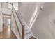Elegant staircase with carpeted steps and white railings leading to the upper level, next to a hard wood floor at 3925 Massey Pointe Ct, Raleigh, NC 27616