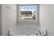 Bathroom featuring a large soaking tub beneath a window at 4044 Dunkirk Dr, Burlington, NC 27215