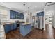 Open kitchen with granite countertops, stainless steel appliances, and modern blue cabinets at 4044 Dunkirk Dr, Burlington, NC 27215