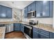 Well-equipped kitchen with granite countertops, stainless steel appliances, and stylish blue cabinets at 4044 Dunkirk Dr, Burlington, NC 27215