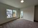 Sunlit bedroom with neutral carpet and windows showcasing the exterior yard at 4310 Emeline Way # 18, Fuquay Varina, NC 27526