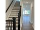 Inviting entry hallway with wood floors, staircase, and a view into a bright and open living space at 4310 Emeline Way # 18, Fuquay Varina, NC 27526