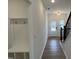 Hallway with hardwood floors, white walls, and a bench near the front door at 4310 Emeline Way # 18, Fuquay Varina, NC 27526