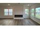 Bright living room with a modern fireplace, wood floors, and large windows overlooking the neighborhood at 4310 Emeline Way # 18, Fuquay Varina, NC 27526