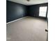 Relaxing bedroom with dark blue walls, neutral carpet, and a bright window at 5016 Gailardia Dr, Zebulon, NC 27597