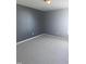 Neutral bedroom features gray walls, light carpet, bright overhead lighting, and a single window at 5016 Gailardia Dr, Zebulon, NC 27597