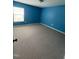 Cozy bedroom features blue walls, neutral carpet, and ample natural light from the window at 5016 Gailardia Dr, Zebulon, NC 27597