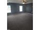 This large carpeted bedroom features two windows and dark gray walls at 5016 Gailardia Dr, Zebulon, NC 27597