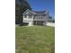 Charming two-story home with a stone facade, solar panels, and a well-manicured lawn on a sunny day at 5016 Gailardia Dr, Zebulon, NC 27597