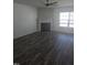 Open-concept living room with dark wood-style flooring, fireplace, and abundant natural light at 5016 Gailardia Dr, Zebulon, NC 27597