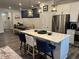 Modern eat-in kitchen featuring an island with barstools, stainless steel refrigerator and dining nook at 5045 Kota St, Raleigh, NC 27610