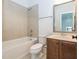Cozy bathroom with a tiled tub, neutral walls, and a wood-colored vanity and mirror at 5347 Cypress Ln, Raleigh, NC 27609