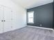 A bright bedroom showcasing carpet, a gray accent wall, and a window for natural light at 5347 Cypress Ln, Raleigh, NC 27609