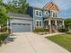 Charming two-story home featuring a covered front porch and a two-car garage with stone accents at 5347 Cypress Ln, Raleigh, NC 27609