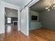 Spacious hallway featuring hardwood floors and a barn door leading to a living room with a TV at 5347 Cypress Ln, Raleigh, NC 27609