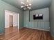 Stylish living room featuring green walls, hardwood floors, built-in cabinets, and a modern light fixture at 5347 Cypress Ln, Raleigh, NC 27609