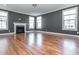 Neutral living room featuring a fireplace, hardwood floors, and large windows that bring in natural light at 5347 Cypress Ln, Raleigh, NC 27609