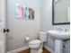 Stylish powder room with a pedestal sink, wood floors, and modern artwork at 5347 Cypress Ln, Raleigh, NC 27609