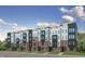 Row of modern townhomes featuring a brick facade, dark trim, and roof top terraces at 600 Hedrick Ridge Road # 112, Cary, NC 27519