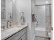 Clean bathroom features a gray vanity with a marble countertop and a shower-tub with white subway tile at 602 Gray Ave, Durham, NC 27701