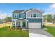 Charming two-story home featuring a covered front porch, well-manicured lawn, and a two-car garage at 6529 Winter Spring Dr, Wake Forest, NC 27587