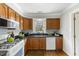 Kitchen featuring hardwood floors, wooden cabinets, and white appliances at 6750 Olde Province Ct, Raleigh, NC 27609