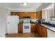 Bright kitchen with white appliances and wooden cabinets at 6750 Olde Province Ct, Raleigh, NC 27609