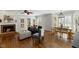 Inviting living room featuring a cozy fireplace, hardwood floors, and plenty of natural light from large windows at 6750 Olde Province Ct, Raleigh, NC 27609