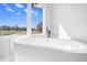 Close-up of a modern soaking tub situated beneath a bright window at 73 Clyde Pearce Rd, Zebulon, NC 27597