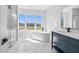 Elegant bathroom features a soaking tub under a window and marble tile flooring at 73 Clyde Pearce Rd, Zebulon, NC 27597