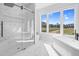 Bright bathroom featuring a soaking tub, glass shower and three large windows at 73 Clyde Pearce Rd, Zebulon, NC 27597