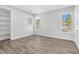 Bright bedroom featuring three windows, a built-in shelf, and hard wood flooring at 73 Clyde Pearce Rd, Zebulon, NC 27597