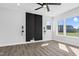 Bedroom with hard wood flooring, large windows, a fan, and black accent wall at 73 Clyde Pearce Rd, Zebulon, NC 27597