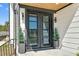 Modern front door with sidelights, potted trees, and a covered porch welcomes you home at 73 Clyde Pearce Rd, Zebulon, NC 27597