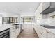 Bright, modern kitchen with white cabinets, stainless steel appliances, and an open layout to the pool at 73 Clyde Pearce Rd, Zebulon, NC 27597