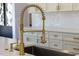 Close-up of a modern kitchen sink with a stylish gold spring faucet at 73 Clyde Pearce Rd, Zebulon, NC 27597